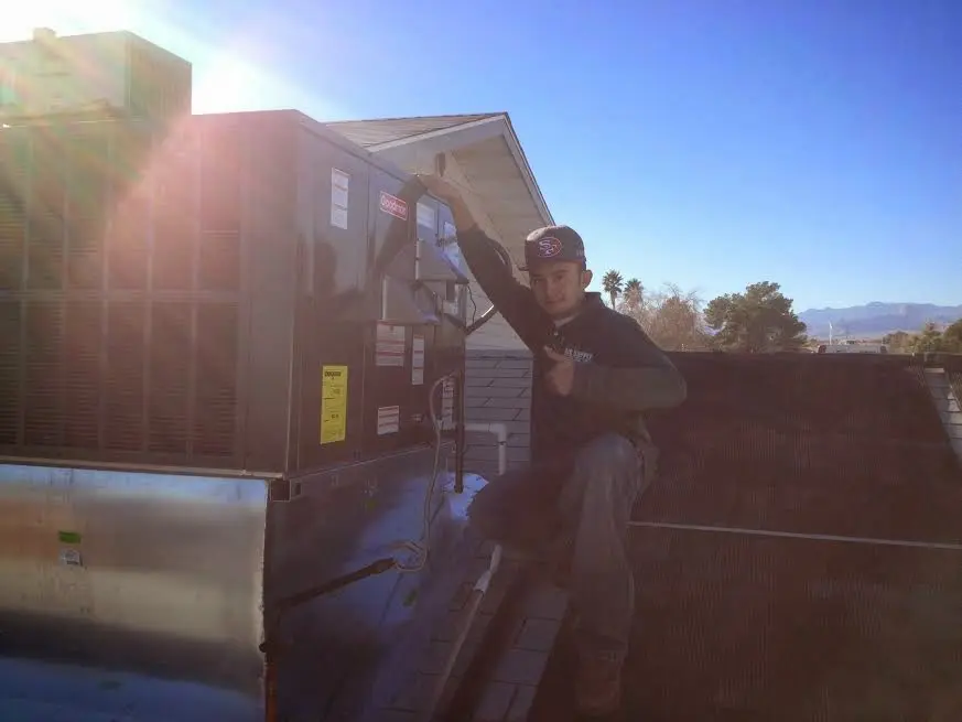HVAC technician performing AC Tune-Up on a rooftop unit in Pinewood